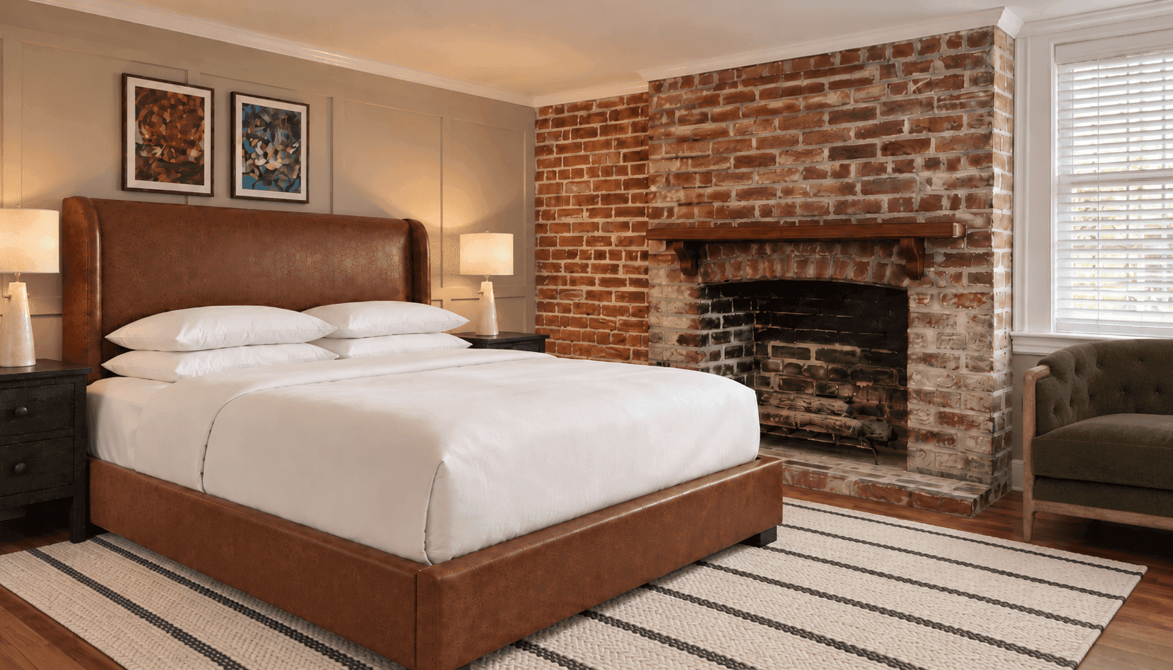 Heritage King room at Sabal House Inn in historic Savannah, featuring a king-size bed, exposed brick fireplace, hardwood floors, and preserved architectural details.