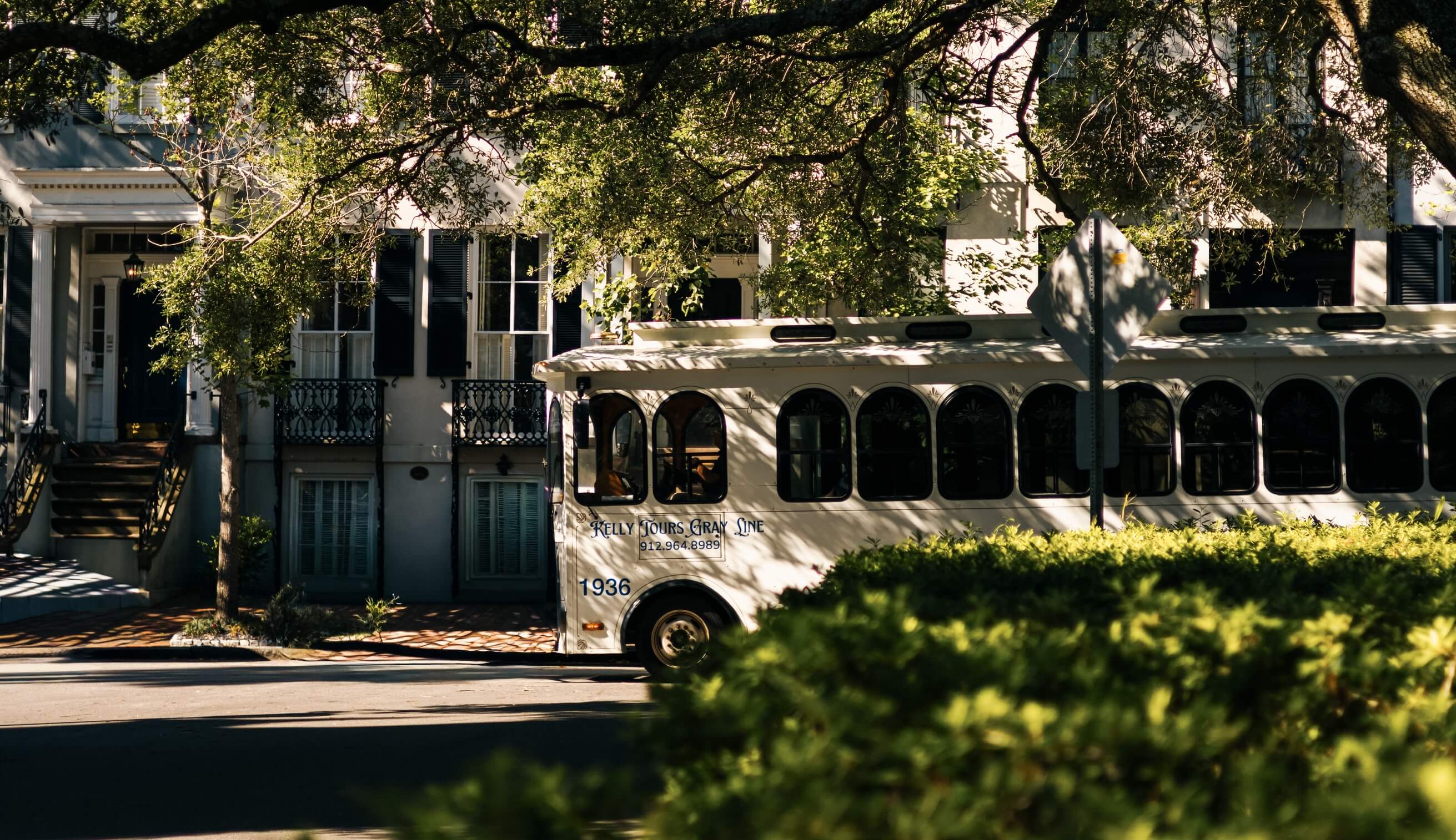 Extior of the boutque Sabal House hotel with a Savannah Trolley tour driving by